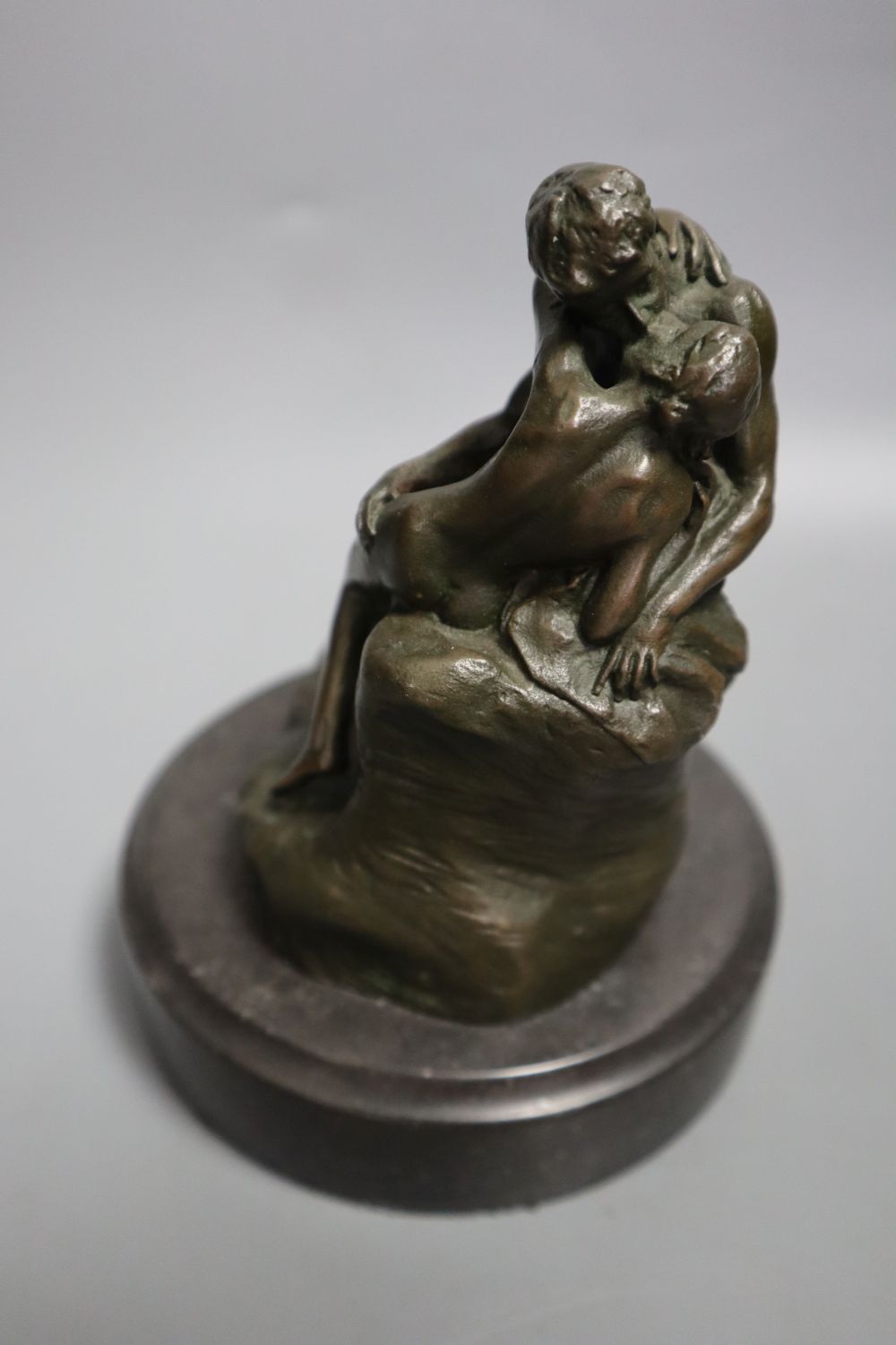 A cast metal sculpture Kiss after Rodin, height 14cm and another of Arabs